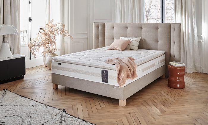 Un matelas en âme Hybride avec un sommier et tête de lit en beige.